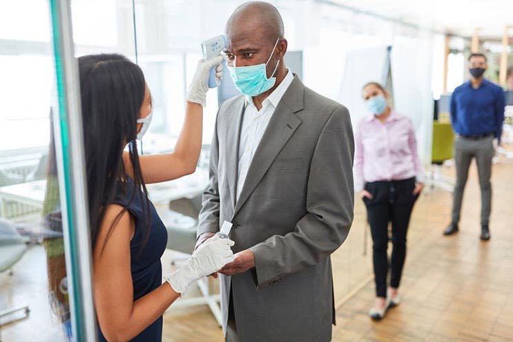 a woman checking employees temperatures