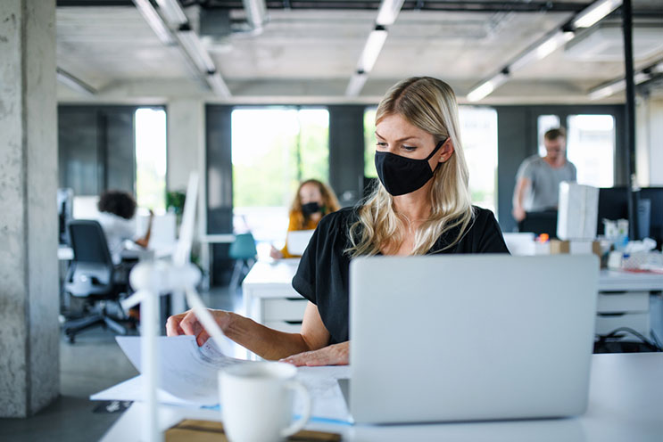 a woman in an office wearing a mask