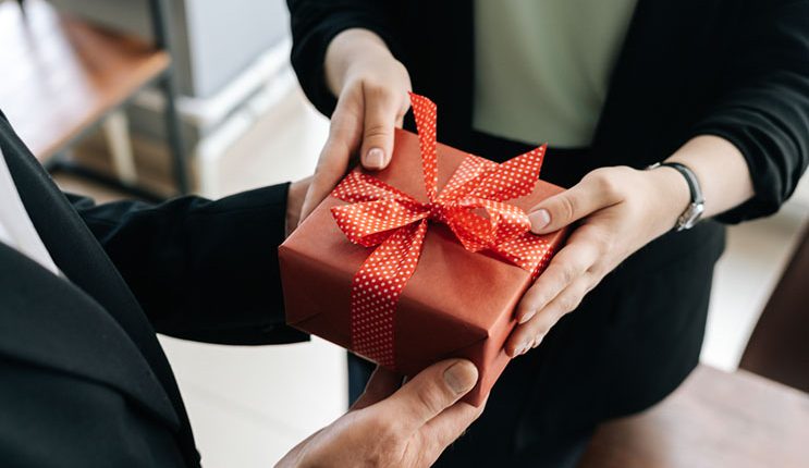 handing gift box to employee