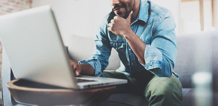 man browsing internet on laptop